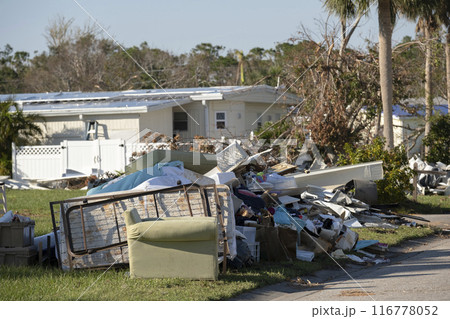 Metallic scrap rubbish on roadside from hurricane severely damaged houses in Florida residential area. Aftermath of natural disaster Metallic scrap rubbish on roadside from hurricane severely damaged houses in Florida residential area. Aftermath of natural disaster 116778052