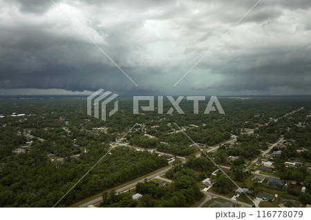Landscape of dark ominous clouds forming on stormy sky before heavy thunderstorm over rural town area Landscape of dark ominous clouds forming on stormy sky before heavy thunderstorm over rural town area 116778079
