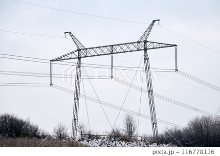 High voltage tower with electric power lines transfening electrical energy through cable wires 116778116