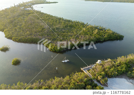 Half sunken sailing yacht capsized on shallow bay waters after hurricane Ian in Manasota, Florida Half sunken sailing yacht capsized on shallow bay waters after hurricane Ian in Manasota, Florida 116778162