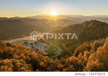 View from above of big parking rest area for cars and trucks near busy American highway with fast moving traffic. Recreational place in Appalachian mountains for interstate travel 116778231