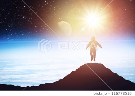Silhouette of an astronaut levitating against the background of the planet. Elements of this image courtesy of NASA 116778516