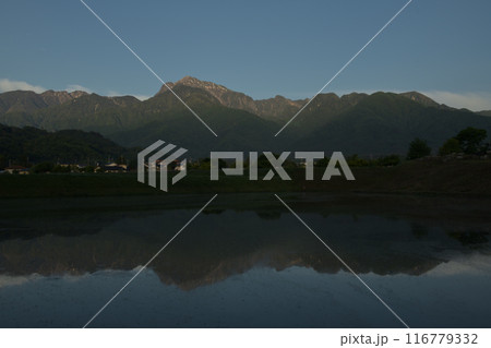 北杜市白州町、昇る朝日が南アルプス甲斐駒ケ岳とその山並みを照らし水田のみな面に映る 北杜市白州町、昇る朝日が南アルプス甲斐駒ケ岳とその山並みを照らし水田のみな面に映る 116779332