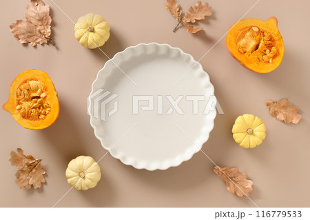 Autumn pumpkins, fall leaves, empty baking dish. Concept cook Pumpkin pie on beige background. Top view. Thanksgiving Day. 116779533