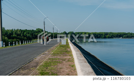 People walking along the road along the embankment 116780103