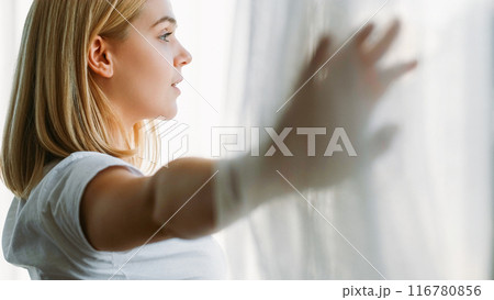 Morning start. Motivation moment. Daylight energy. Inspired positive calm girl opening curtains smiling enjoying refreshing contemplating looking through window. Morning start. Motivation moment. Daylight energy. Inspired positive calm girl opening curtains smiling enjoying refreshing contemplating looking through window. 116780856