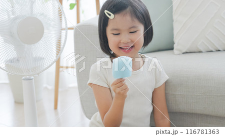 夏休みに扇風機の前でアイスを食べる子供 116781363