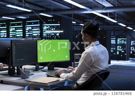 Admin in data center using diagnostic tools and system monitoring software on green screen PC to identify root cause of errors. IT expert in server farm repairing infrastructure with mockup computer Admin in data center using diagnostic tools and system monitoring software on green screen PC to identify root cause of errors. IT expert in server farm repairing infrastructure with mockup computer 116781468