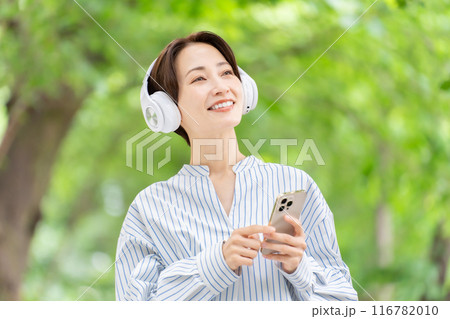 ヘッドホンで音楽を聴く女性 新緑 ヘッドホンで音楽を聴く女性 新緑 116782010