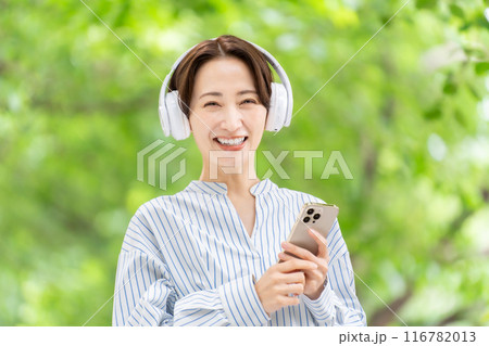 ヘッドホンで音楽を聴く女性　新緑 116782013
