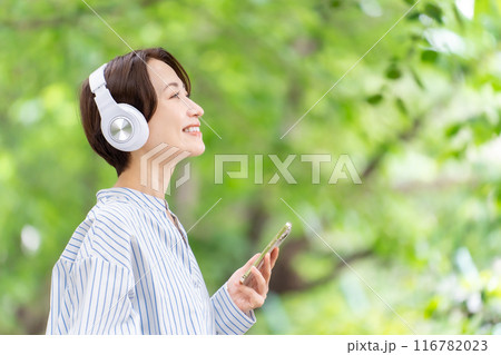 ヘッドホンで音楽を聴く女性　新緑 116782023