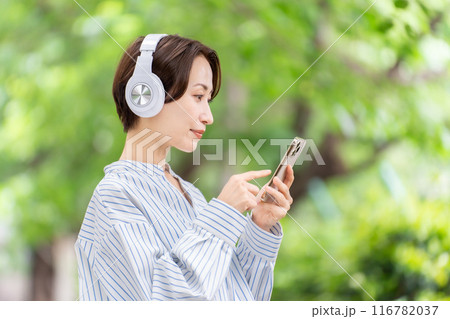 ヘッドホンで音楽を聴く女性　新緑 116782037
