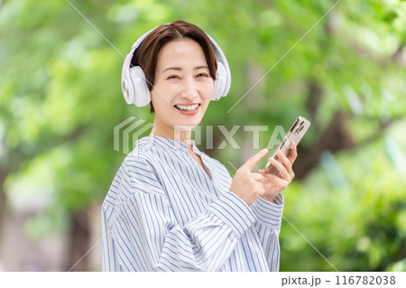 ヘッドホンで音楽を聴く女性 新緑 ヘッドホンで音楽を聴く女性 新緑 116782038