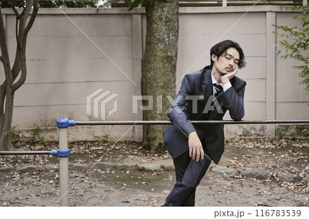 屋外で鉄棒に寄りかかる男性 116783539