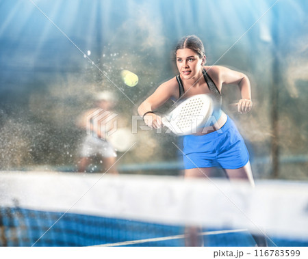 Portrait of girl paddle tennis player during friendly doubles couple match at court 116783599