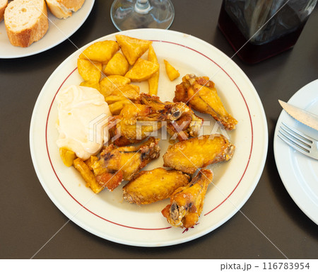 Tasty chicken wings with with gravy and potatoes Tasty chicken wings with with gravy and potatoes 116783954
