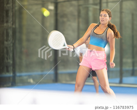 Padel game - girl with partners plays on tennis court Padel game - girl with partners plays on tennis court 116783975