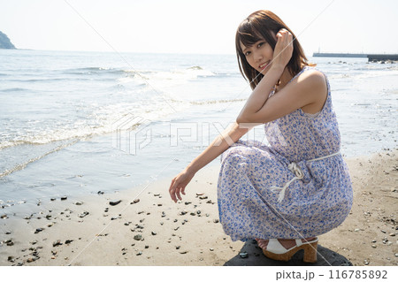 砂浜にしゃがむ女性 116785892