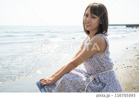 砂浜にしゃがむ女性 116785893