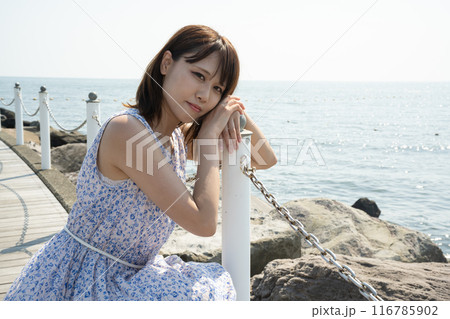 海をバックにポーズをとる女性 116785902