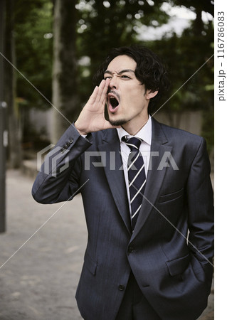 屋外にいる表情豊かなスーツ姿の男性 116786083