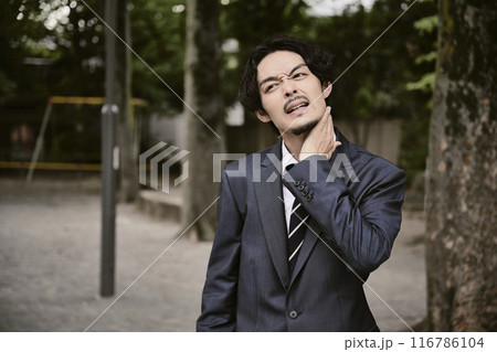 屋外にいる表情豊かなスーツ姿の男性 116786104