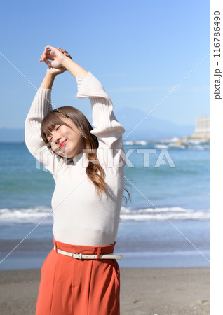 砂浜をバックにポーズを取る女性 116786490