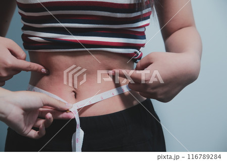 Women body fat belly. Obese woman hand holding excessive belly fat. diet lifestyle concept to reduce belly and shape up healthy stomach muscle. Women body fat belly. Obese woman hand holding excessive belly fat. diet lifestyle concept to reduce belly and shape up healthy stomach muscle. 116789284
