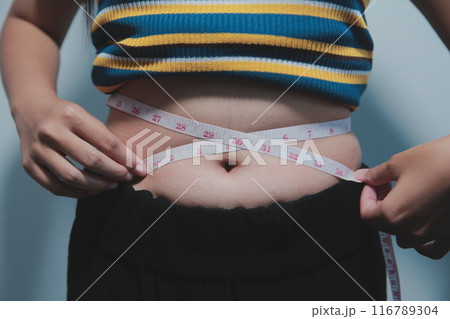Women body fat belly. Obese woman hand holding excessive belly fat. diet lifestyle concept to reduce belly and shape up healthy stomach muscle. 116789304