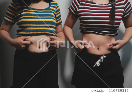 Women body fat belly. Obese woman hand holding excessive belly fat. diet lifestyle concept to reduce belly and shape up healthy stomach muscle. Women body fat belly. Obese woman hand holding excessive belly fat. diet lifestyle concept to reduce belly and shape up healthy stomach muscle. 116789315