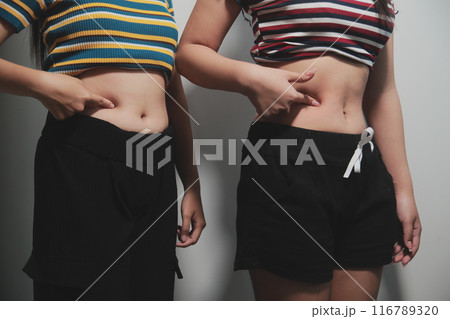 Women body fat belly. Obese woman hand holding excessive belly fat. diet lifestyle concept to reduce belly and shape up healthy stomach muscle. Women body fat belly. Obese woman hand holding excessive belly fat. diet lifestyle concept to reduce belly and shape up healthy stomach muscle. 116789320
