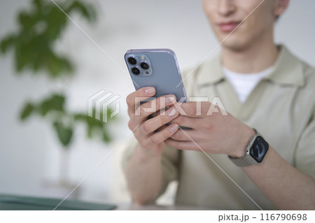 スマートフォンを操作するマニキュアをした若い男性の手元 スマートフォンを操作するマニキュアをした若い男性の手元 116790698