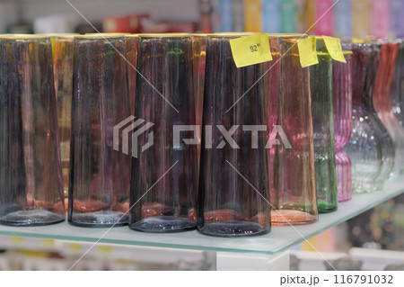 Colored glassware are sold in shop. Jars for bouquets of flowers. 116791032