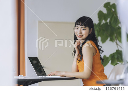 ノートパソコンで作業をする若い女性　カメラ目線　ポートレート 116791613