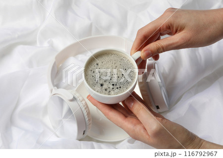 A cup of coffee with headphones on a white background 116792967