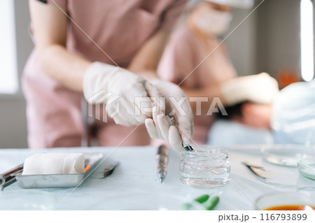 Close-up hands of nurse holding syringe with liquid vaccines working in modern hospital. Closeup of unrecognizable female doctor in latex gloves fill in syringe with medicine from glass bottle. Close-up hands of nurse holding syringe with liquid vaccines working in modern hospital. Closeup of unrecognizable female doctor in latex gloves fill in syringe with medicine from glass bottle. 116793899