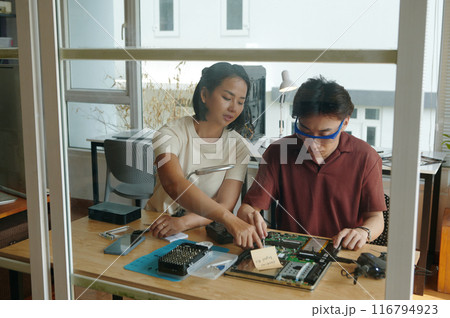 Colleagues Repairing Broken Laptop In Team 116794923
