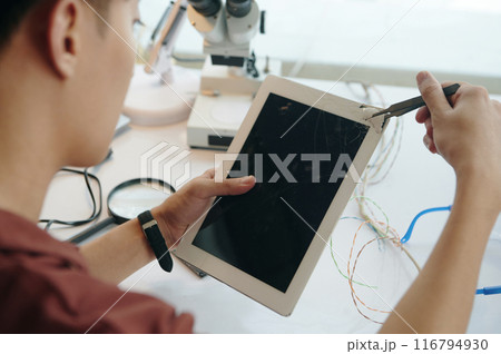 Man Repairing Broken Screen In Workshop 116794930