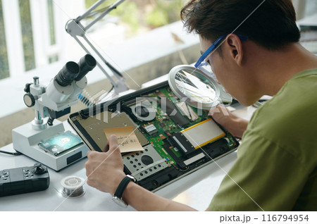 Repairman Using Magnifier At His Work 116794954