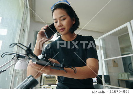 Technician Discussing Repair Of Drone With Customer Technician Discussing Repair Of Drone With Customer 116794995
