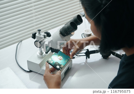 Master Examining Disk Under Microscope Master Examining Disk Under Microscope 116795075