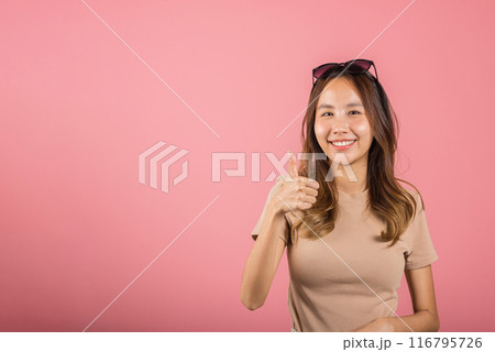 Portrait Asian beautiful young woman smiling she standing made finger thumbs up, Ok sign to agree studio shot isolated on pink background, Thai female successful like finger gesture with copy space Portrait Asian beautiful young woman smiling she standing made finger thumbs up, Ok sign to agree studio shot isolated on pink background, Thai female successful like finger gesture with copy space 116795726