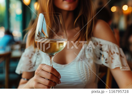 Solitary woman at restaurant table with glass of wine Solitary woman at restaurant table with glass of wine 116795728