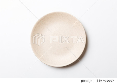 Top view of isolated of colored background empty round beige plate for food. Empty dish with space for your design Top view of isolated of colored background empty round beige plate for food. Empty dish with space for your design 116795957