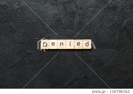 DENIED word written on wood block. DENIED text on cement table for your desing, concept 116796162