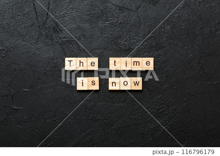 the time is now word written on wood block. the time is now text on table, concept the time is now word written on wood block. the time is now text on table, concept 116796179