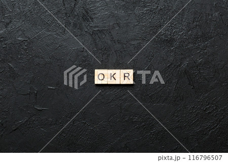 OKR word written on wood block. abbreviation of Objective Key Results text on cement table for your desing, concept 116796507