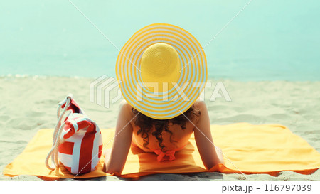 Summer vacation, beautiful happy relaxing young woman with tourist hat lying on the beach at sea 116797039