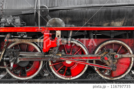 Red wheels and details of vintage black steam locomotive, close-up 116797735