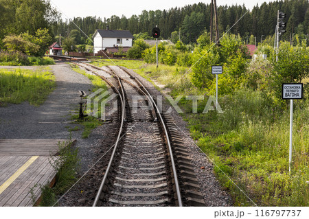 An empty railway track turning left with a railway switch An empty railway track turning left with a railway switch 116797737